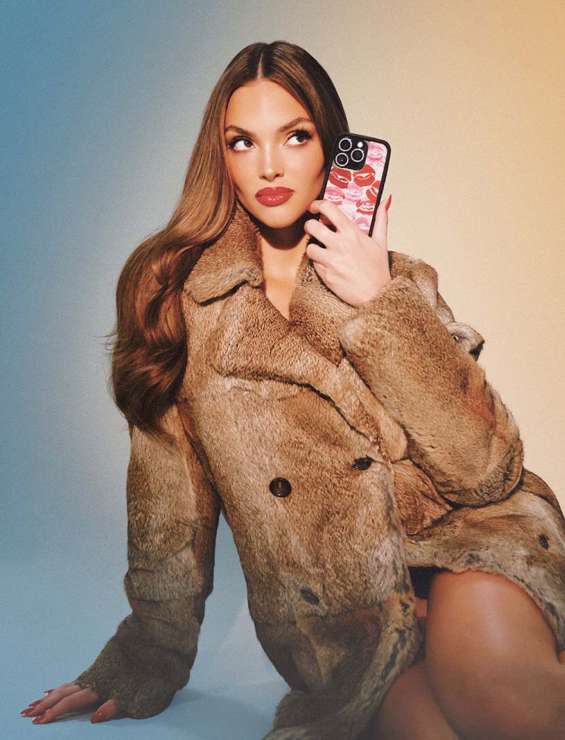 Kensington Tillo poses in a fur coat with her custom case covered in pink and red kisses