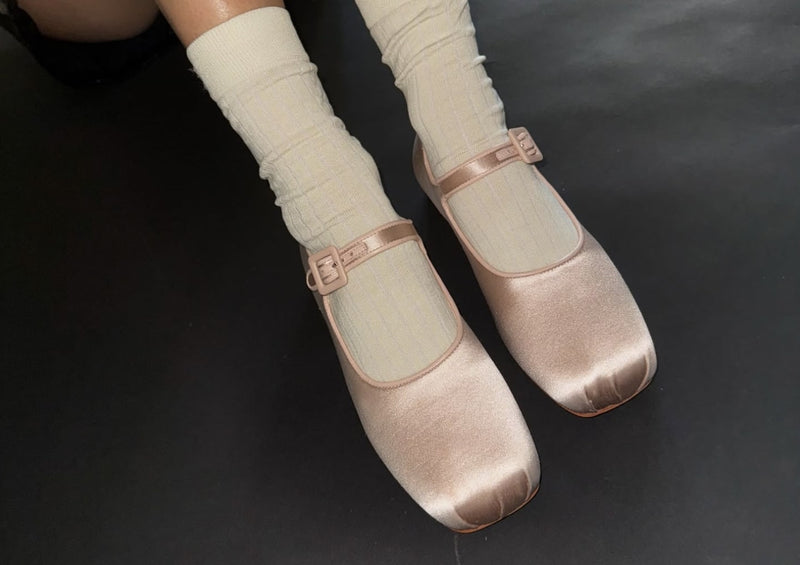 Close up of two legs to show white socks and ballet shoes