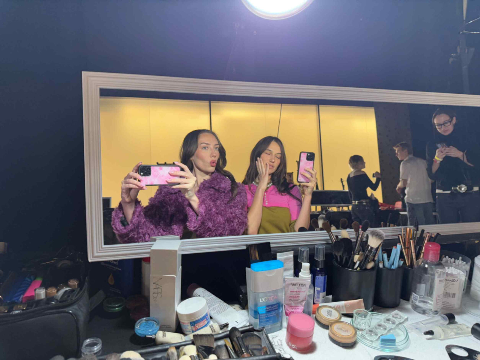 Devon and Sydney Carlson take a mirror selfie at a makeup glam table