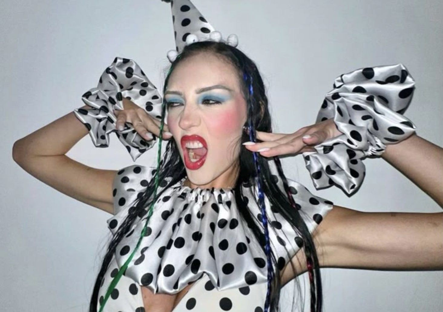 Sydney Carlson dresses as a clown in a black and white polka dot outfit