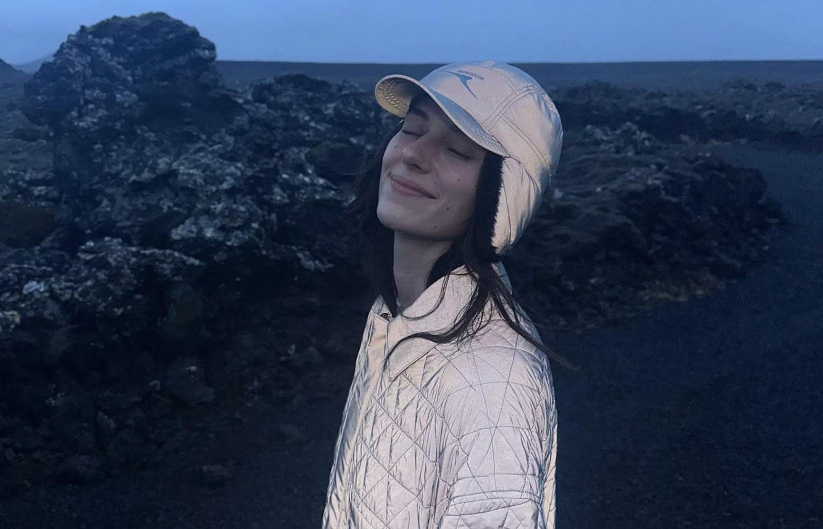 Devon Lee Carlson poses in a white coat and white snow hat