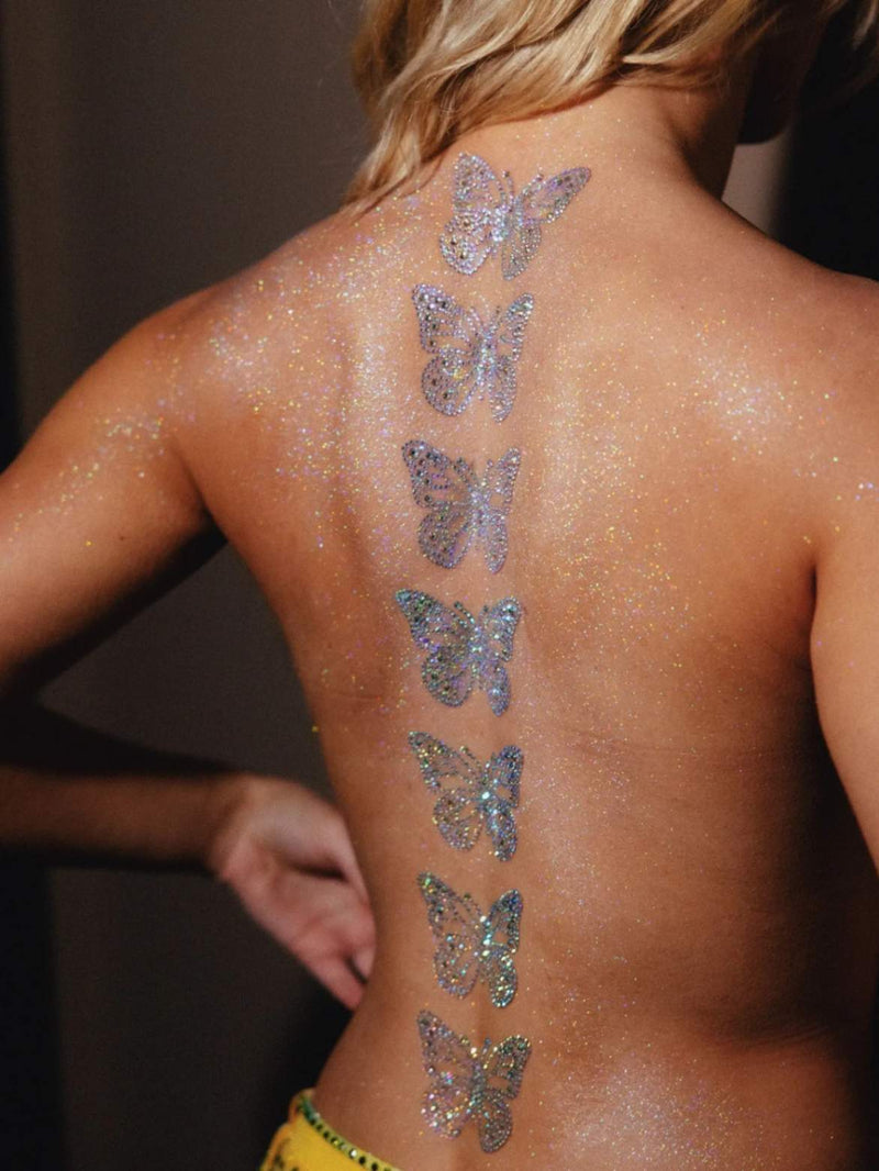 A bare back shown with glitter butterflies drawn on going straight down the middle
